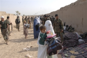 Afghan soldiers hand out supplies to Afghans